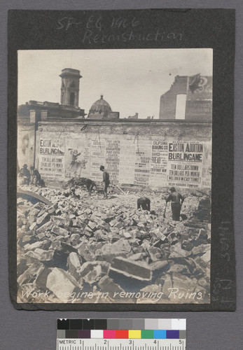 Work begins in removing ruins. [Ruins of City Hall in background.]