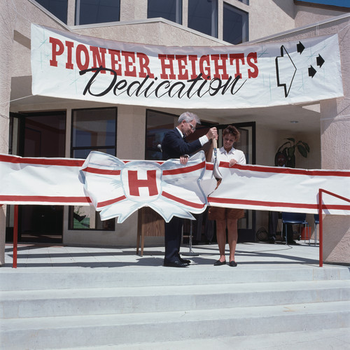 120 mm Direct Positive of Ellis E. McCune and unknown girl (student) cutting the ribbon at the Pioneer Heights Dedication Ceremony