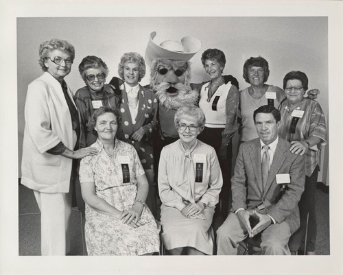 Photograph of eight women and one man with mascot Pioneer Pete