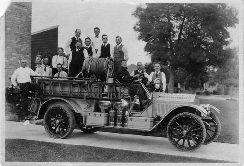 Upland Photograph Public Services; Upland Fire Department fire fighters posed on parked fire truck/ William Churchill Cline