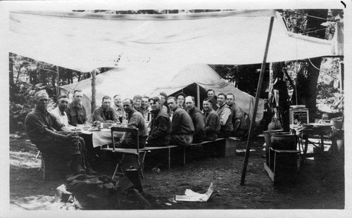 Upland Photograph Events: Upland Fire Department Camping Trip: 17 men seated around a table at Big Pines, CA