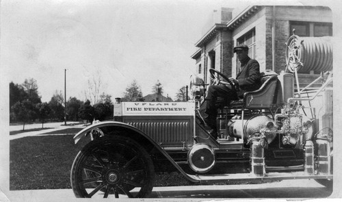 Upland Photograph Public Services; Upland Fire Department Howard C. Paulin seated on fire truck