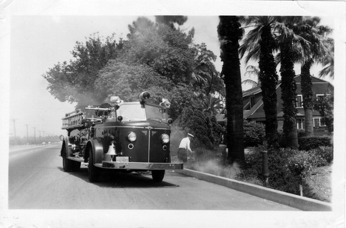 Upland Photograph Public Services; Upland Fire Department fire truck and fire fighter responding to fire on Foothill Blvd. / L. T. Gotchy