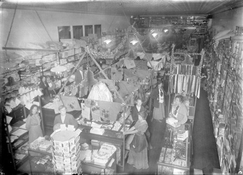 Upland Photograph Business; Interior view of the E.H. Haury & Co. Dry Goods and Variety Store decorated for Christmas, staff and customers are in this photograph / Edna Swan