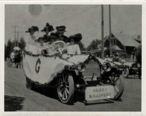 Upland Photograph Events; Parade: Gerry Millinery advertised by 8 women all wearing hats, seated in a decorated automobile / Melicent Arner