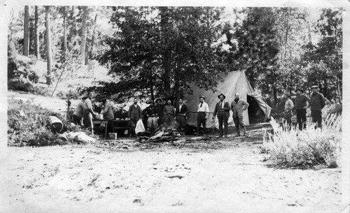 Upland Photograph Events; Upland Fire Department Camping Trip: 14 men posed in front of a tent or cleaning dishes in Mt. Baldy, CA