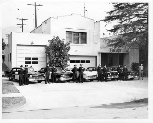 Upland Photograph Public Services; Upland Police Department: 11 officers standing by patrol cars in front of Upland Police Department