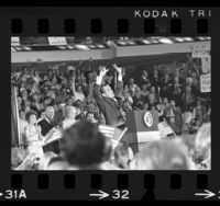 Richard Nixon on podium with raised arms, gesturing "V" for victory at Republican rally in Anaheim, Calif., 1970