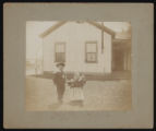 Two children in front of house
