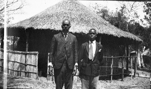 African men standing in front of a hut, southern Africa