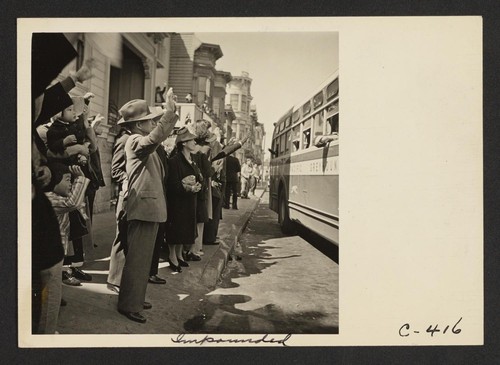 Inhabitants of the Japanese section wave farewell at the departure of their friends and neighbors whom they are soon to