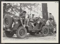 Hot Mississippi. Members of the 442nd combat team drape themselves on a jeep to dress after a cool swim in