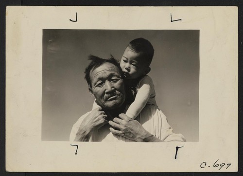 Manzanar, Calif.--Grandfather and grandson of Japanese ancestry at this War Relocation Authority center. Photographer: Lange, Dorothea Manzanar, California