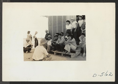 Poston, Ariz.--Norris James, WRA representative, gives instructions and assignments to the newspaper staff of evacuees of Japanese ancestry at this War Relocation Authority center. Photographer: Stewart, Francis Poston, Arizona