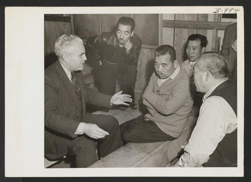 Dr. P. A. Weber, from the WRA office in Salt Lake City, who speaks fluent Japanese, talks with some of the evacuees during the visit of a Relocation Team to the Rohwer Project. Photographer: Van Tassel, Gretchen McGehee, Arkansas