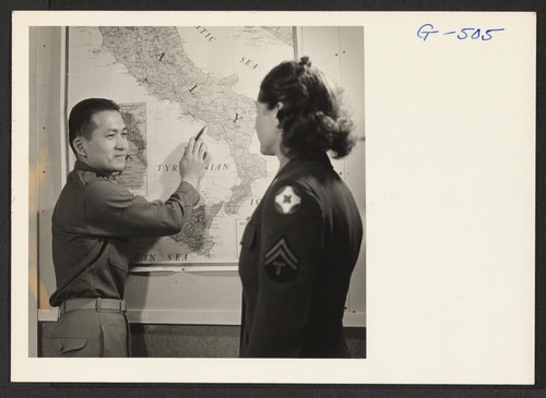 1st Lt. Shigeru Tsubota points out where he was serving in Italy with the 100th Battalion to a WAC corporal. Lt. Tsubota is at the Moore General Hospital recovering from a leg wound received in action overseas. Photographer: Van Tassel, Gretchen Swannanoa, North Carolina