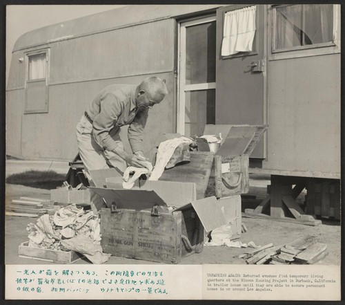 Unpacking belongings in this temporary trailer home at the Winona Housing Project in Burbank, California, where returned evacuees find temporary living quarters until they are able to secure homes in or around Los Angeles, Calif. Photographer: Parker, Tom Burbank, California