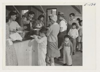 Dinner is served cafeteria style to young and old in the mess halls at the Heart Mountain Relocation Center. Photographer: Parker, Tom Heart Mountain, Wyoming
