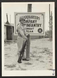 Private Noyama of Headquarters Company, 442nd combat team, stands guard at the entrance to Field Headquarters. The combat team wears