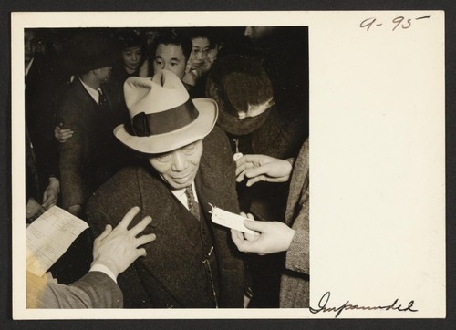 Just about to step into the bus for the Assembly Center. Photographer: Lange, Dorothea San Francisco, California