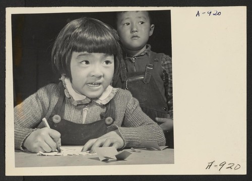 A third grade student at the Manzanar Relocation Center for evacuees of Japanese ancestry practices free hand drawing. This photo