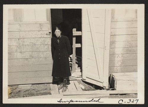 A Japanese woman, just evacuated, who arrived this morning is shown at the door of her living quarters. Each door enters into a family unit of two small rooms (remodeled horse-stalls). Photographer: Lange, Dorothea San Bruno, California