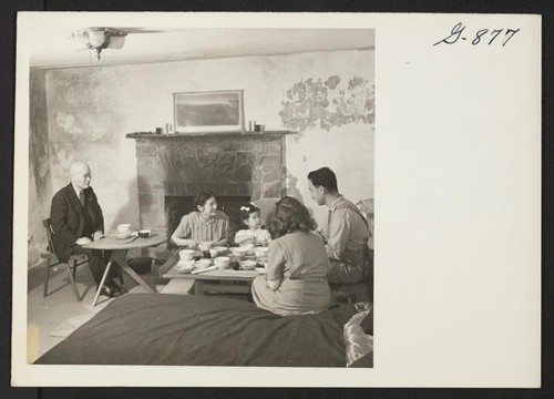 The Nakashima family and Mrs. Nakashima's father and sister from Minidoka enjoy an informal supper around a low table in