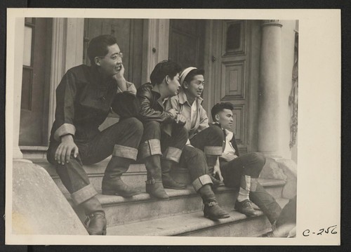 High school boys look over Buchanan Street scene, prior to evacuation of residents of Japanese ancestry. Evacuees of Japanese ancestry will be housed in War Relocation Authority centers for the duration. Photographer: Lange, Dorothea San Francisco, California