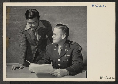 Lieutenant Eugene Bogard, Commanding Officer of the Army Registration team, explains to young evacuees details of volunteering in the Army Combat team, which is being organized and made up entirely of Japanese-Americans. Photographer: Stewart, Francis Manzanar, California