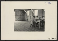 Manzanar, Calif.--The staff of the Japanese language section of the Manzanar Free Press conferring with the editor, Joe Blamey. Photographer: Lange, Dorothea Manzanar, California