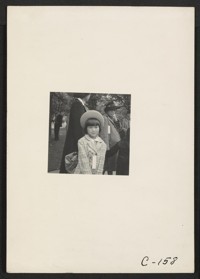 Hayward, Calif.--A young member of an evacuee family awaiting evacuation bus. Evacuees of Japanese ancestry will be housed in War Relocation Authority centers for the duration. Photographer: Lange, Dorothea Hayward, California