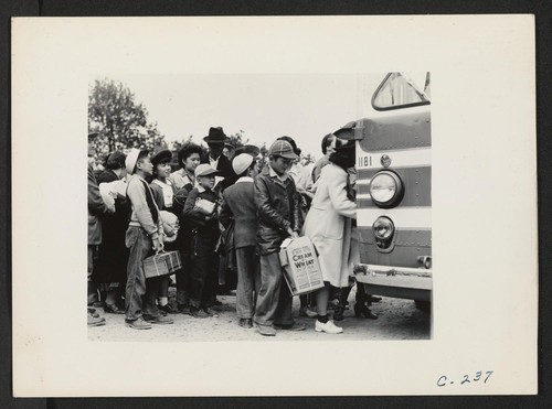 Members of farm families board evacuation buses. Evacuees of Japanese ancestry will be housed in War Relocation Authority centers for the duration. Photographer: Lange, Dorothea Centerville, California