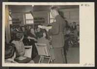 Lieutenant Eugene Bogard explains the method of registration of Japanese and Japanese-Americans to a group of appointed personnel at the Manzanar Center. All evacuees between the ages of 18 and 38 were compelled to register. Photographer: Stewart, Francis Manzanar, California