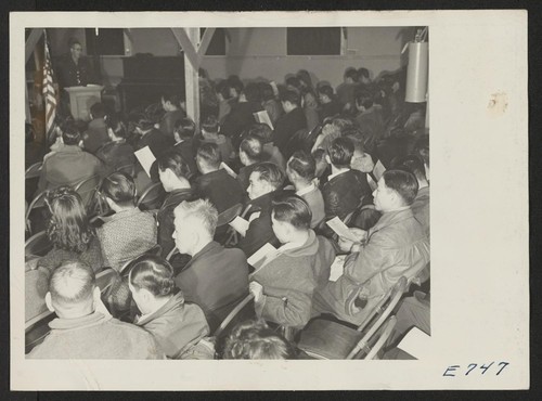 A block group of Japanese and Japanese-Americans, residents at the Granada Relocation Center, listen to an explanation of the army