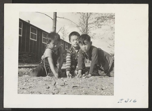 If he's a boy in America he plays marbles, as these lads of Japanese parentage are doing at the Rohwer Relocation Center. Photographer: Parker, Tom McGehee, Arkansas