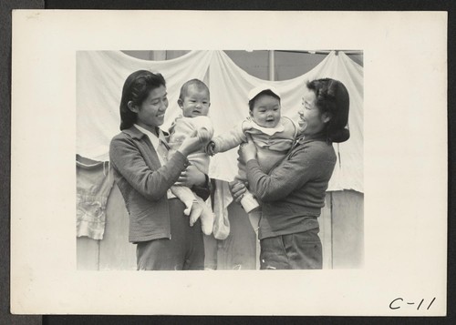 Arcadia, Calif.--Evacuee mothers, with their babies, getting acquainted at the Santa Anita Assembly center where evacuees from this area are awaiting transfer to a War Relocation Authority center to spend the duration. Photographer: Albers, Clem Arcadia, California