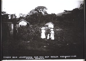 Children carrying clay for the building of the Basel Mission station in Nyasoso, Cameroon