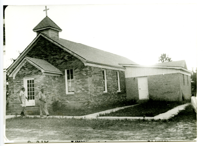 Two men walking outside of C.M.E. church, Lodi, Texas