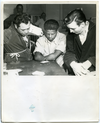 Sammy Workman signing card with two unidentified men