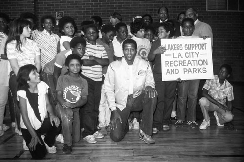 Jamaal Wilkes posing with children and adults at the Harvard Recreation Center, Los Angeles, 1989