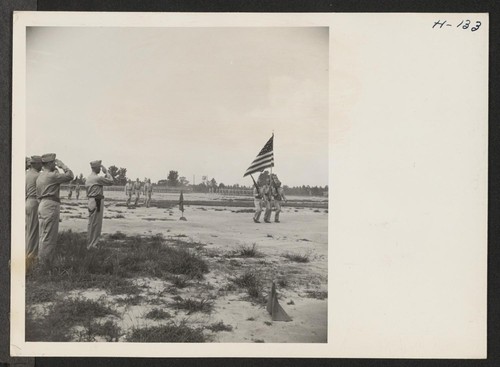 Caucasian and Japanese-American officers of the 442nd combat team at Camp Shelby salute the colors during review. The 442nd combat