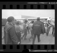 U.S. Immigration agents leading illegal aliens from Lights of America Company factory to buses in City of Industry, Calif., 1986