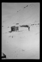 Military camp facilities sitting at the base of a snowy mountainside, Attu Island, 1944