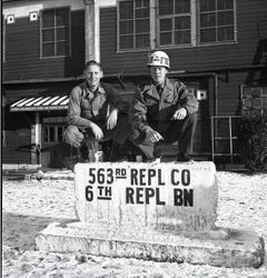 Soldiers posing on sign in front of barracks at Camp Drake in Japan ...