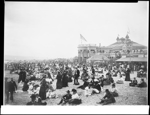Crowds of people on the beach near the bath house in Long Beach, ca.1906