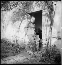 [Artist / sculptor Henri Edouard Navarre outside country cottage and ceramics studio]