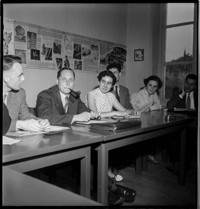 [College Europe: Bruges. Group in class or conference room, with industrial posters on wall.]