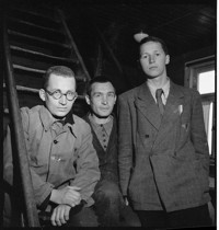 [Buchenwald intellectuals. Liberated prisoners, one with "P" trianle patch on jacket (Polish?)]