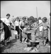 Halte Mayenne. Poeple watching cooking [Refugees. Mayenne, France?]