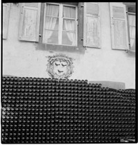 [Miscellaneous: Schoech. Large stack of wine bottles outside winery or chateau, Ammerschwihr?]